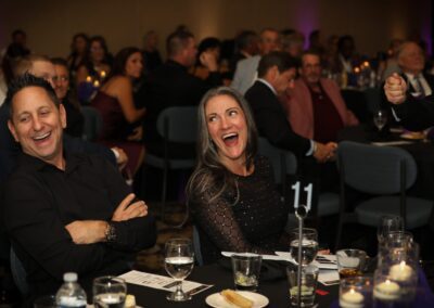 Guests laughing together at their table during a past Night of Light gala