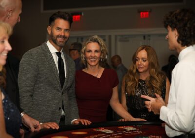 Guests gathered around a blackjack table at Night of Light casino night