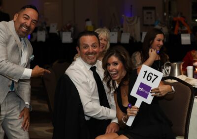Guests raising a bidder paddle during the Night of Light live auction