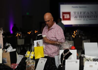 A guest reviewing silent auction packages at Night of Light